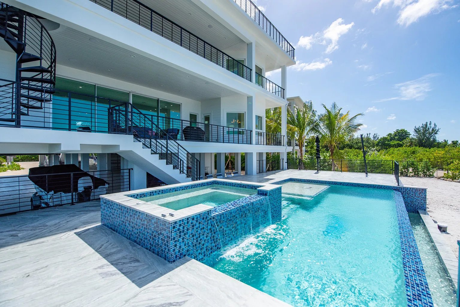 Custom tiled pool and spa with waterfall built by Dream Builders